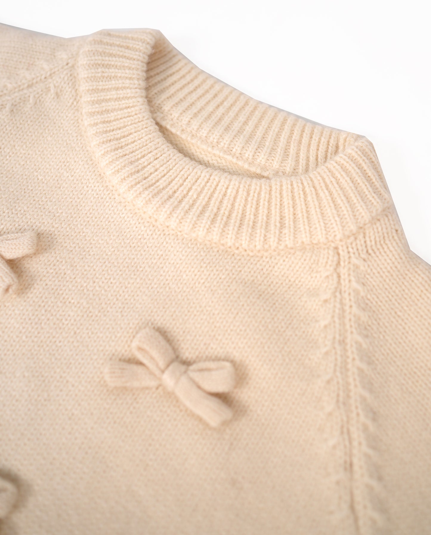 White knit sweater with bow details and frill hem